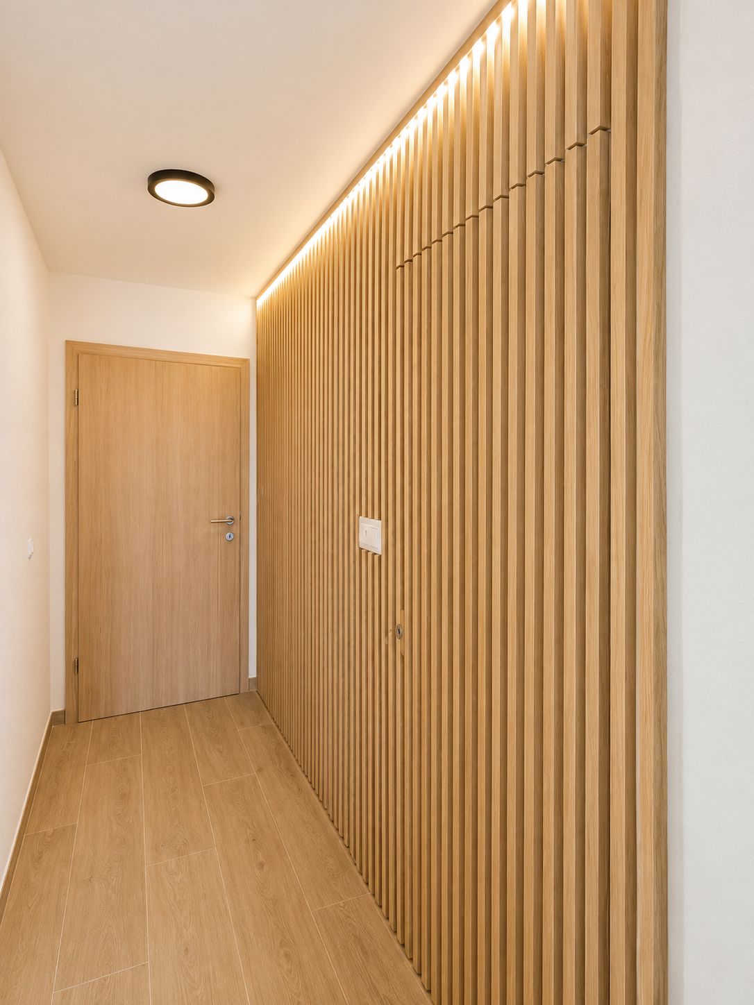 A hallway with a wooden door and a wall with vertical wooden slats.