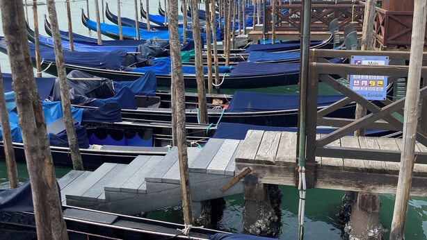 A marina with gondolas docked at wooden piers, a lamp post, and a historic building in the background. - Venice, Ghetto, Campo della Maddalena, Rialto, near train station, Wi-Fi (Venezia)