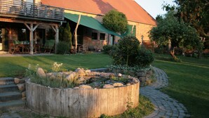 Ein Garten mit Teich aus Holz, Steinstufen und einem Pflasterweg.