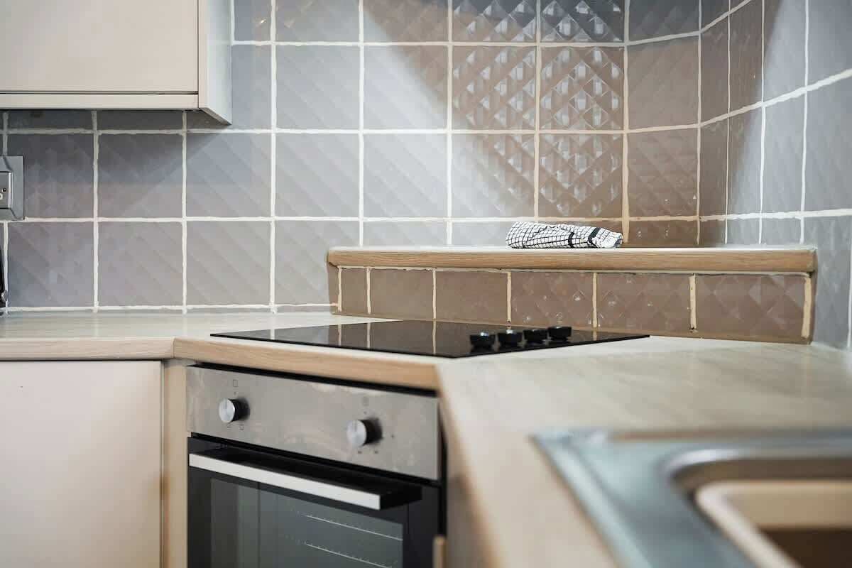 A kitchen with a stove, oven, and a tiled backsplash.