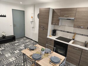 Eine moderne Küche mit Holzausstattung, einer schwarzen Arbeitsplatte und einem gemusterten Boden.