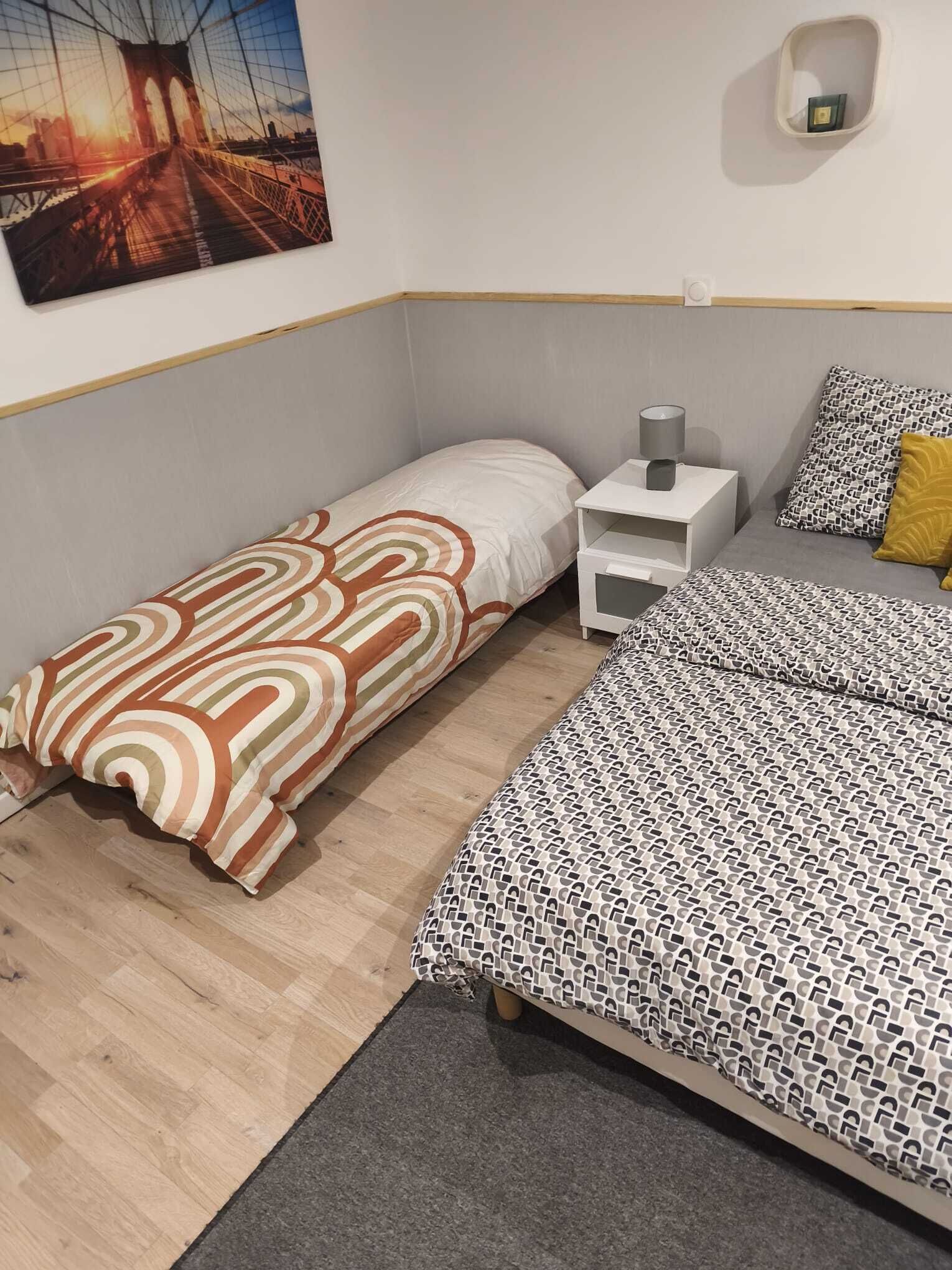 Ein Schlafzimmer mit einem Bett, einem Nachttisch, einer Lampe und einem Wandregal.