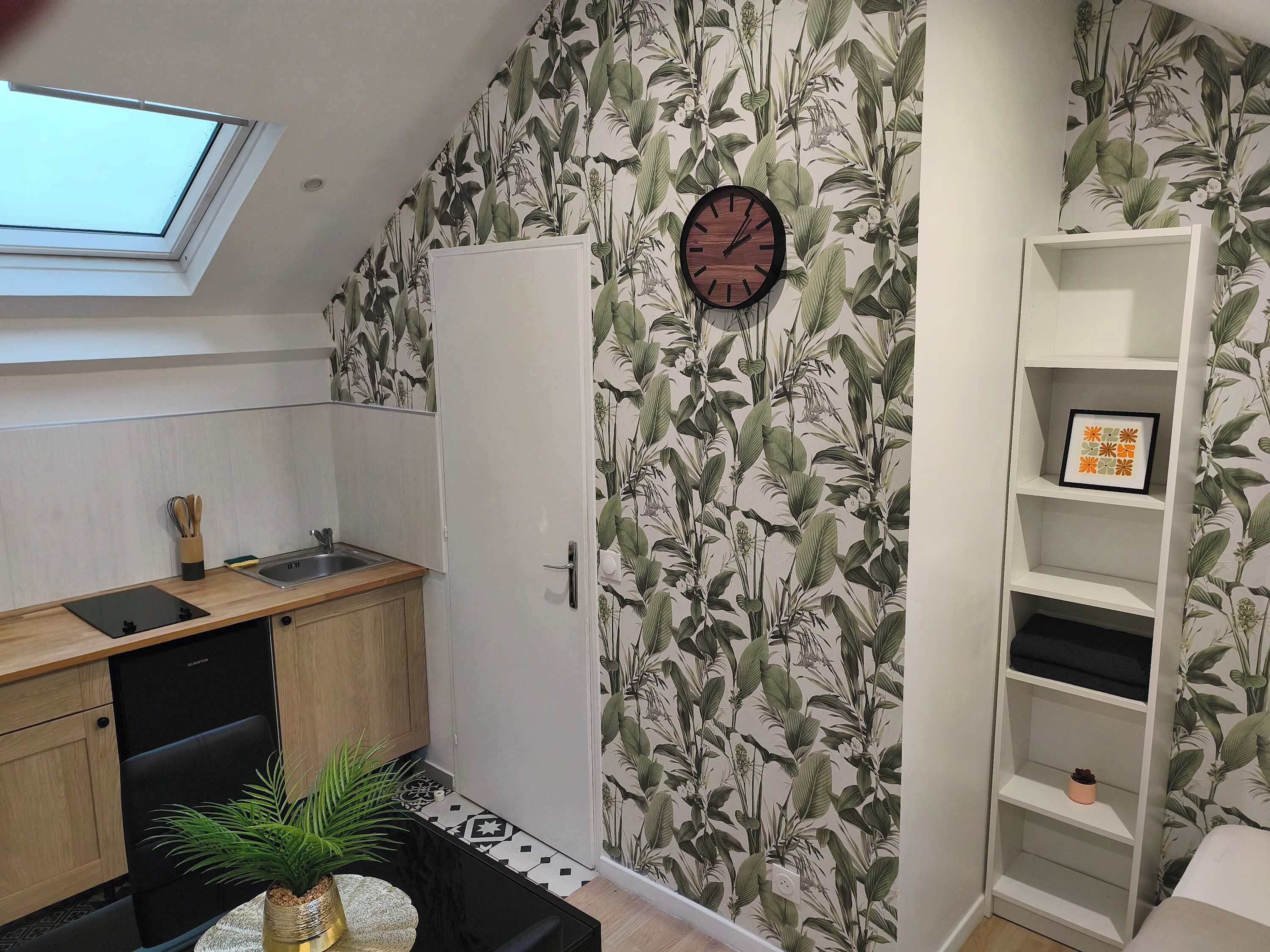 Cocina compacta con tragaluz, un reloj y una planta.