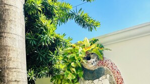 Un jardin avec un mur de pierre, un arbre et diverses plantes.