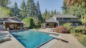 A backyard with a swimming pool, a barbecue area, and a covered patio. - Luxury Wooded Estate With Pool (Sammamish)