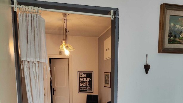 A hallway with a white door, a dining area with a table and chairs, and a framed picture on the wall. - Farmhouse Tenuta Blueberry - Mirtillo - near airport & Lake Maggiore (Cascinetta)