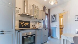 A modern kitchen with stainless steel appliances, a world map decoration, and a motivational quote on the wall. - Farmhouse Tenuta Blueberry - Mirtillo - near airport & Lake Maggiore (Cascinetta)