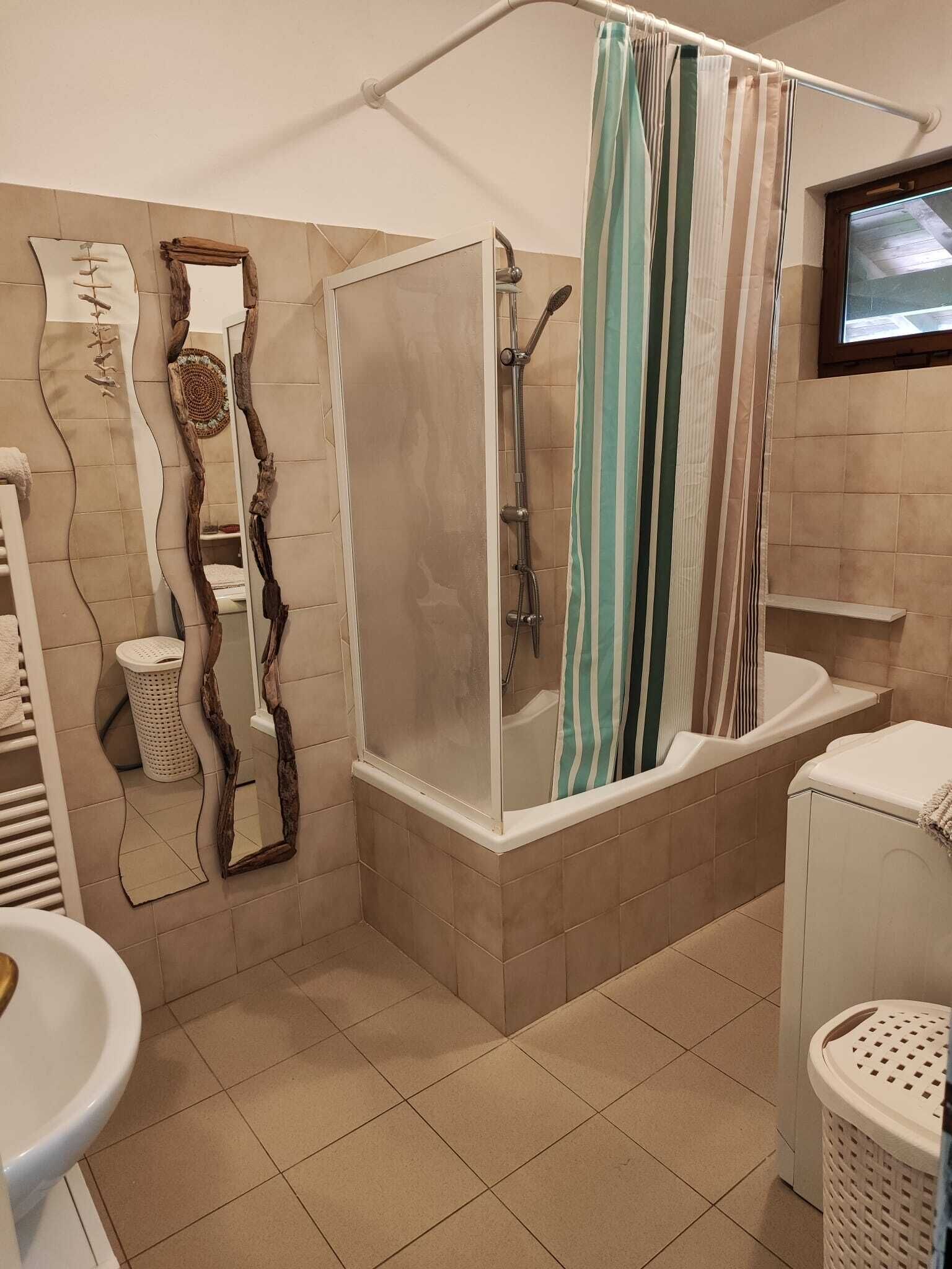 Ein Badezimmer mit Dusche, Toilette, Waschbecken und Spiegel.