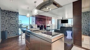 Una cocina moderna con una isla central, electrodomésticos de acero inoxidable e iluminación colgante.
