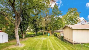 A backyard with a swing set, a shed, and a house. - Inviting Lanham Suite - Quiet and Close to DC! (Lanham)