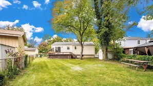 A residential area with a grassy yard, a picnic table, and houses with attached garages. - Inviting Lanham Suite - Quiet and Close to DC! (Lanham)