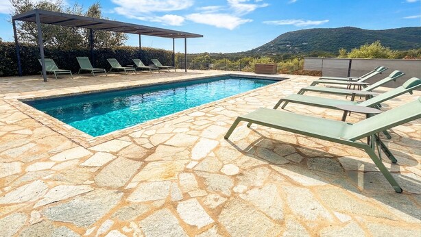 A swimming pool with stone flooring, lounge chairs, and a covered area. - Villa Venti (lieu dit Barbagiolo)