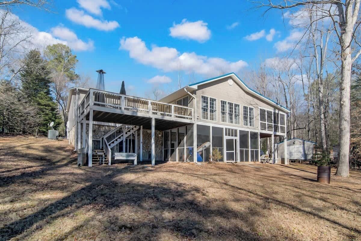 A two-story house with a covered porch and a staircase leading to the upper level.