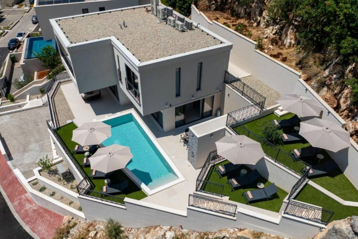Un hôtel moderne doté d’une piscine sur le toit, d’un espace extérieur aménagé et offrant une vue sur le paysage environnant.