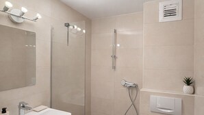 Une salle de bain moderne avec une douche à parois de verre, des toilettes en bois et un lavabo blanc avec un miroir au-dessus.