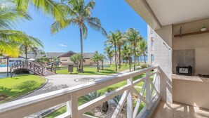 A balcony with a view of a pool, palm trees, and a bridge. - Portamaris Resort - Luxury Apartment by Carpediem (Aquiraz)