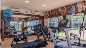 A gym with treadmills, stationary bikes, and exercise balls. - Portamaris Resort - Luxury Apartment by Carpediem (Aquiraz)