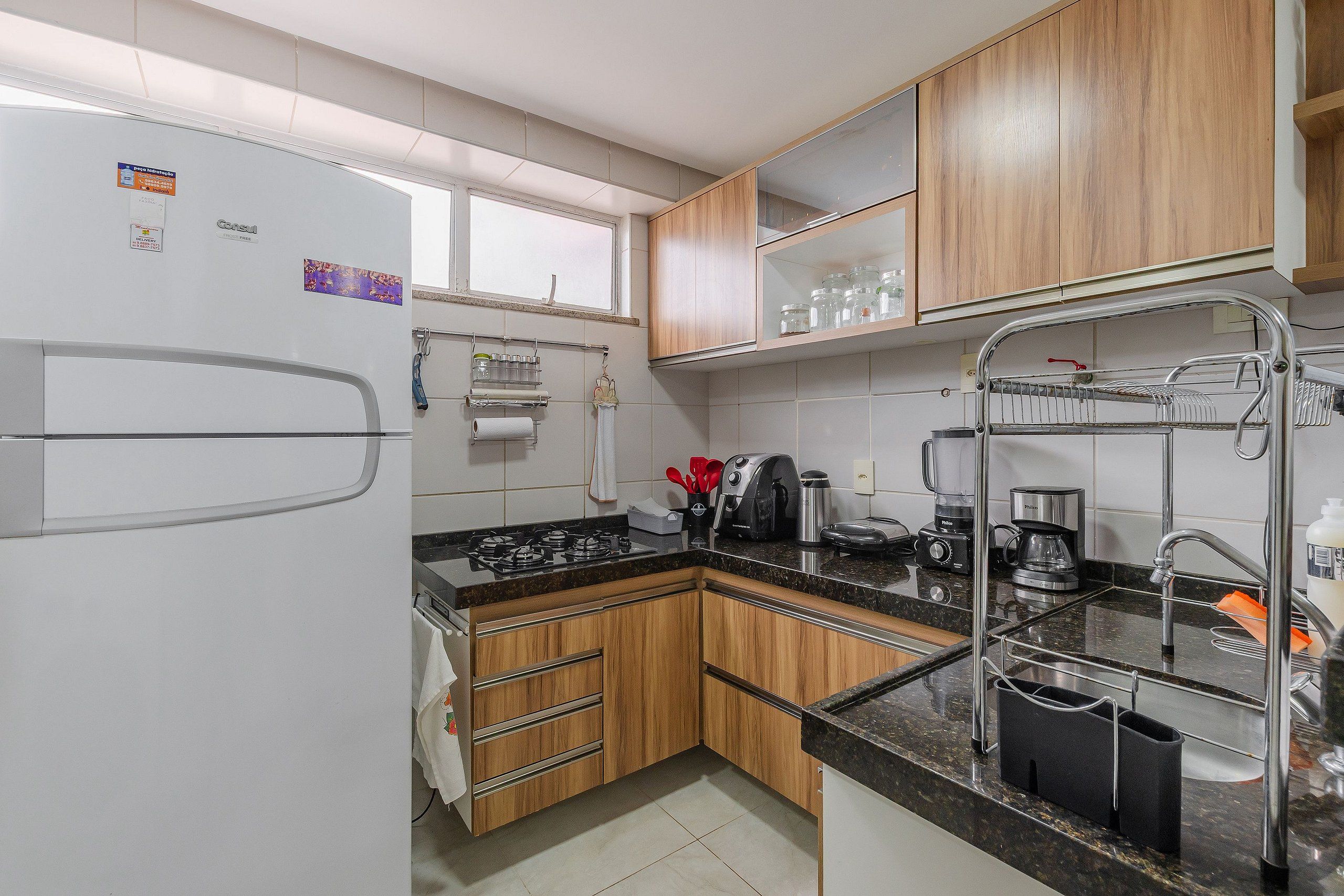 Una cocina moderna con armarios de madera, un lavamanos de acero inoxidable y una estufa a gas.