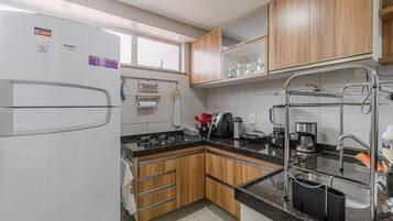 Una cocina moderna con armarios de madera, un lavamanos de acero inoxidable y una estufa a gas.