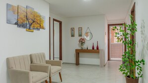 A living room with a beige sofa, a wooden coffee table, and a potted plant. - Scopa Beach #c1-200 - Seafront by Carpediem (Aquiraz)