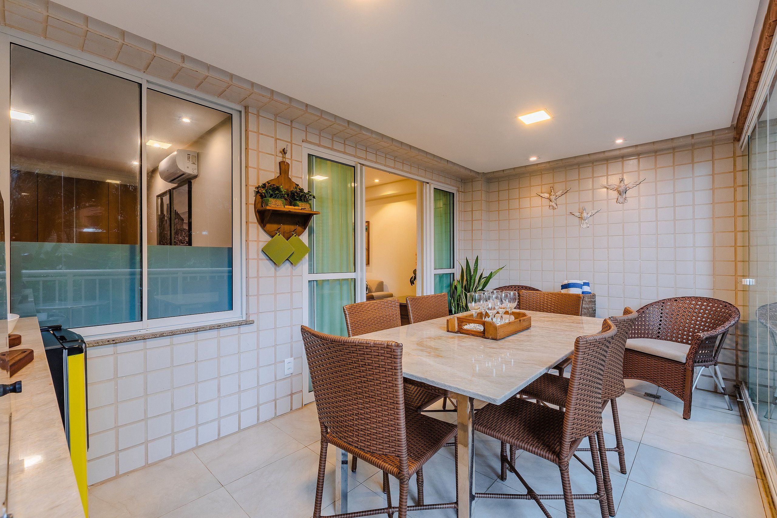 Un comedor con mesa y sillas, una cocina con ventana, y una pared decorada.