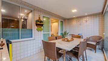 Un comedor con mesa y sillas, una cocina con ventana, y una pared decorada.