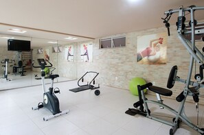 Un gimnasio con equipo de ejercicio, un espejo y un anuncio de Reebok.