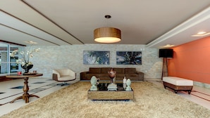 A modern living room with a central coffee table, a sofa, a chair, and a rug. - Scopa Beach #c1-200 - Seafront by Carpediem (Aquiraz)