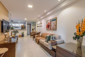 Una sala moderna con sofá, mesa de centro y comedor con sillas y mesa.