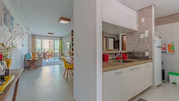 Una cocina moderna con armarios blancos, encimera de granito y horno empotrado.