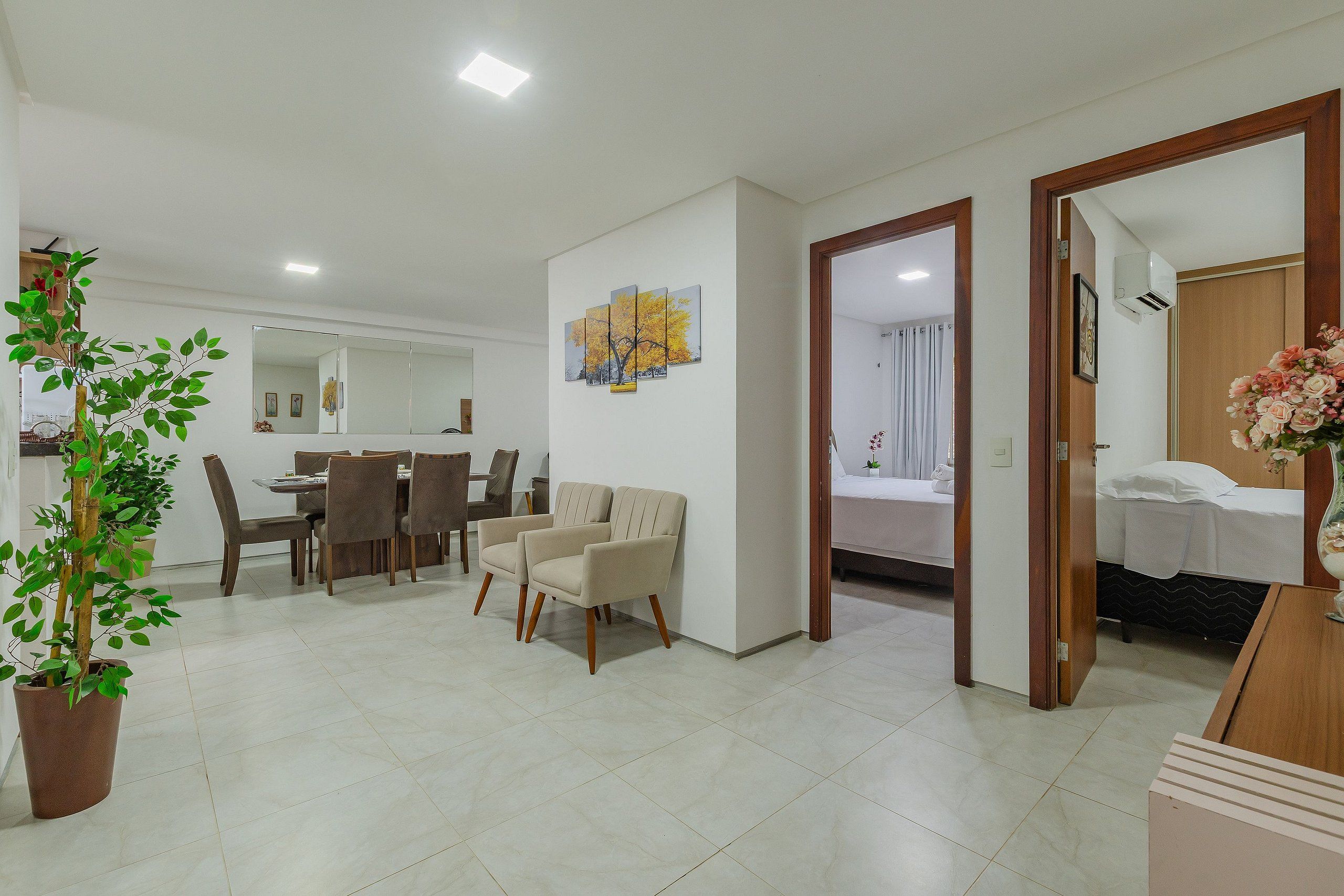 Una habitación de hotel moderna con una cama, una mesita de noche y una planta en maceta.