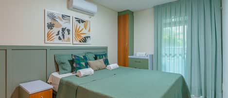 A hotel room with a bed, a nightstand, a wardrobe, and a window with curtains.