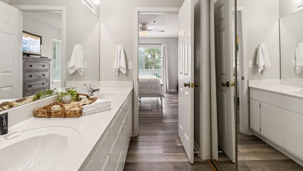 A modern bathroom with a large mirror, white vanity, and a bathtub. - Coastal Escape at Peachtree Place | 2BR Sleeps 8 | Near Beach & Attractions (Panama City Beach)