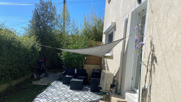A patio with outdoor furniture, a patterned rug, and a yellow soccer ball.