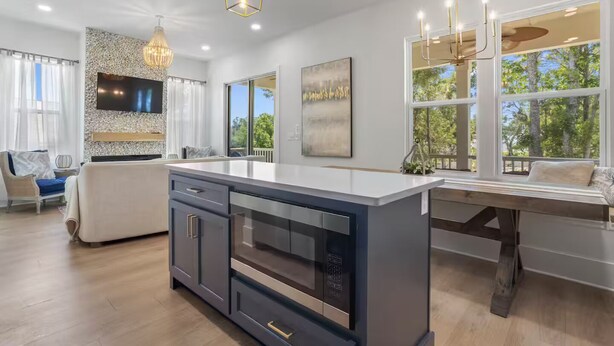 Una cucina moderna con isola centrale, elettrodomestici integrati e zona pranzo con vista sull'esterno.