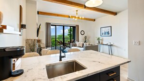 A modern kitchen with a marble countertop, a built-in sink, and a coffee maker. - Bay Views, Covered Patio & Walkable Downtown Sister Bay (Sister Bay)