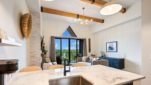 Una cocina moderna con una isla grande, horno empotrado y vistas al exterior.