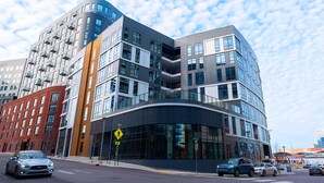 Un immeuble moderne à plusieurs étages, doté de grandes fenêtres et d’une façade incurvée.