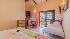 A hotel room with two beds, a desk, and a chair. There is a balcony with a view of palm trees. - Casa Vento - Your Exclusive Refuge by Carpediem (Caucaia)