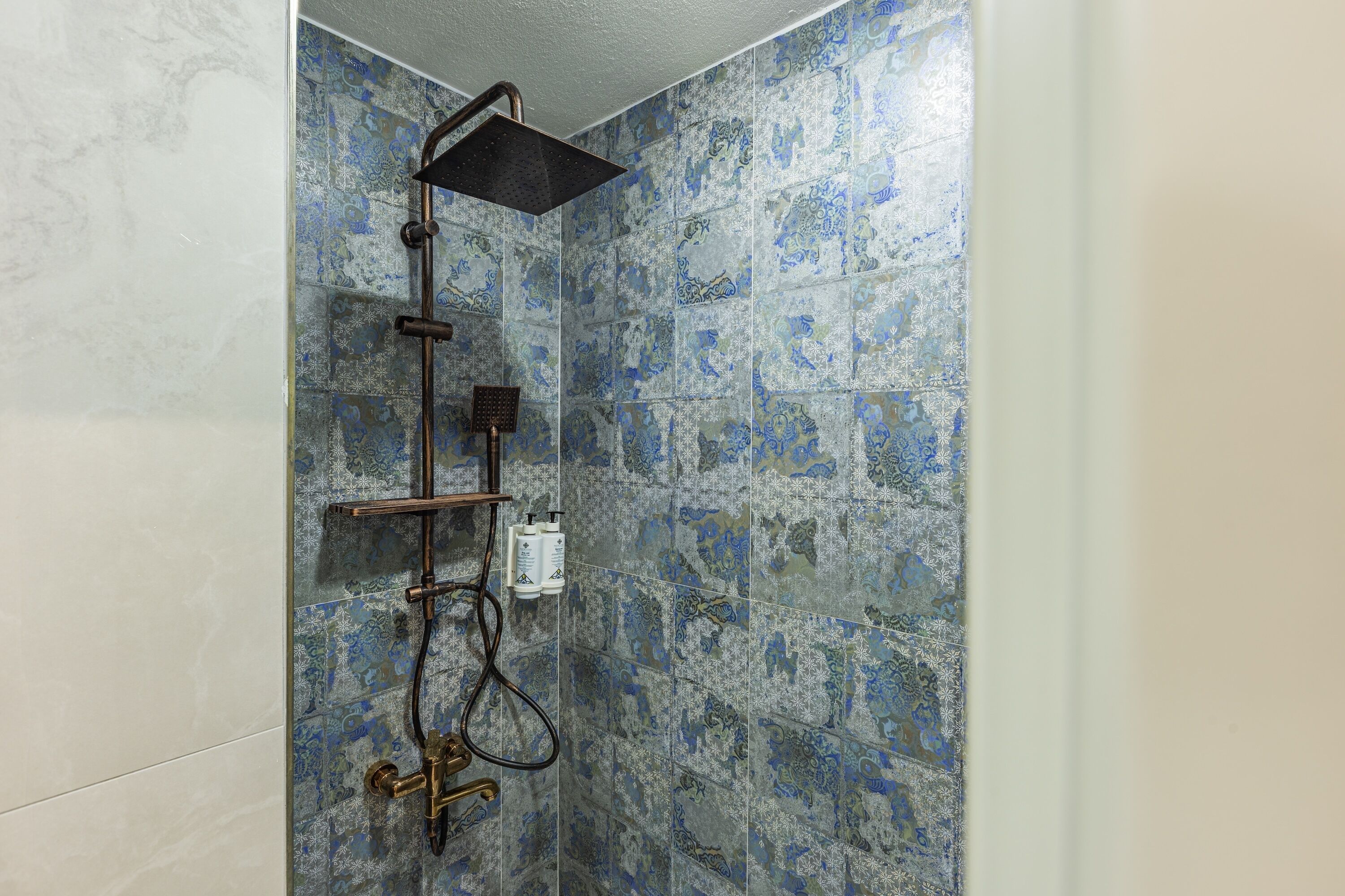 A shower with a rain showerhead, a handheld showerhead, and a handheld scrubber.