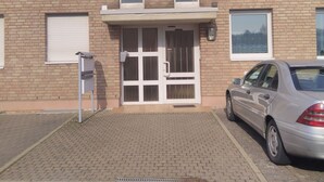 A two-story brick building with a gated entrance, a mailbox, and a parked car. - Vacation apartment Zülpich-Nähe Seepark (Zülpich)