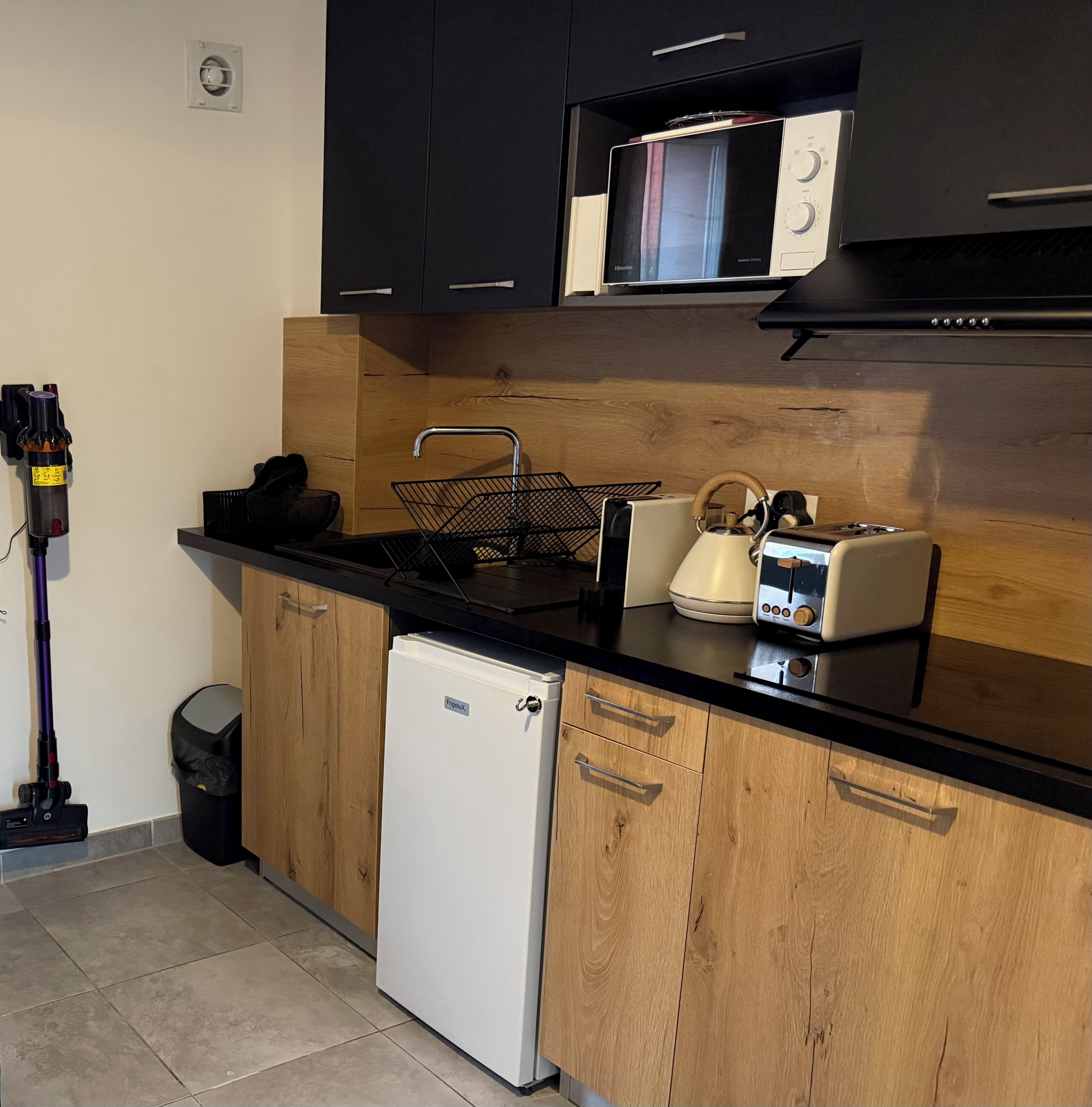 A compact kitchen with a microwave, toaster, and a small refrigerator.