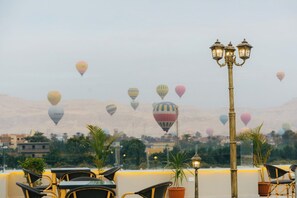 Una terrazza sul tetto con posti a sedere all'aperto e vista su dirigibili in lontananza.