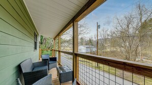 Eine überdachte Veranda mit Korbmöbeln und Blick auf die Straße.