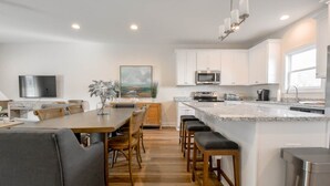 A modern kitchen with white cabinets, a granite countertop, and stainless steel appliances. - Auburn Elite Retreat (Opelika)