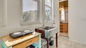 Una cocina con un lavamanos, una ventana y una encimera de madera.