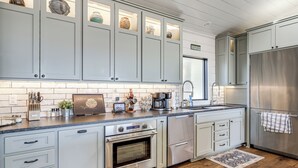 A modern kitchen with light gray cabinets, stainless steel appliances, and a wooden floor. - 'Scenic Overlook' - Luxe Greers Ferry Hideaway! (Fairfield Bay)
