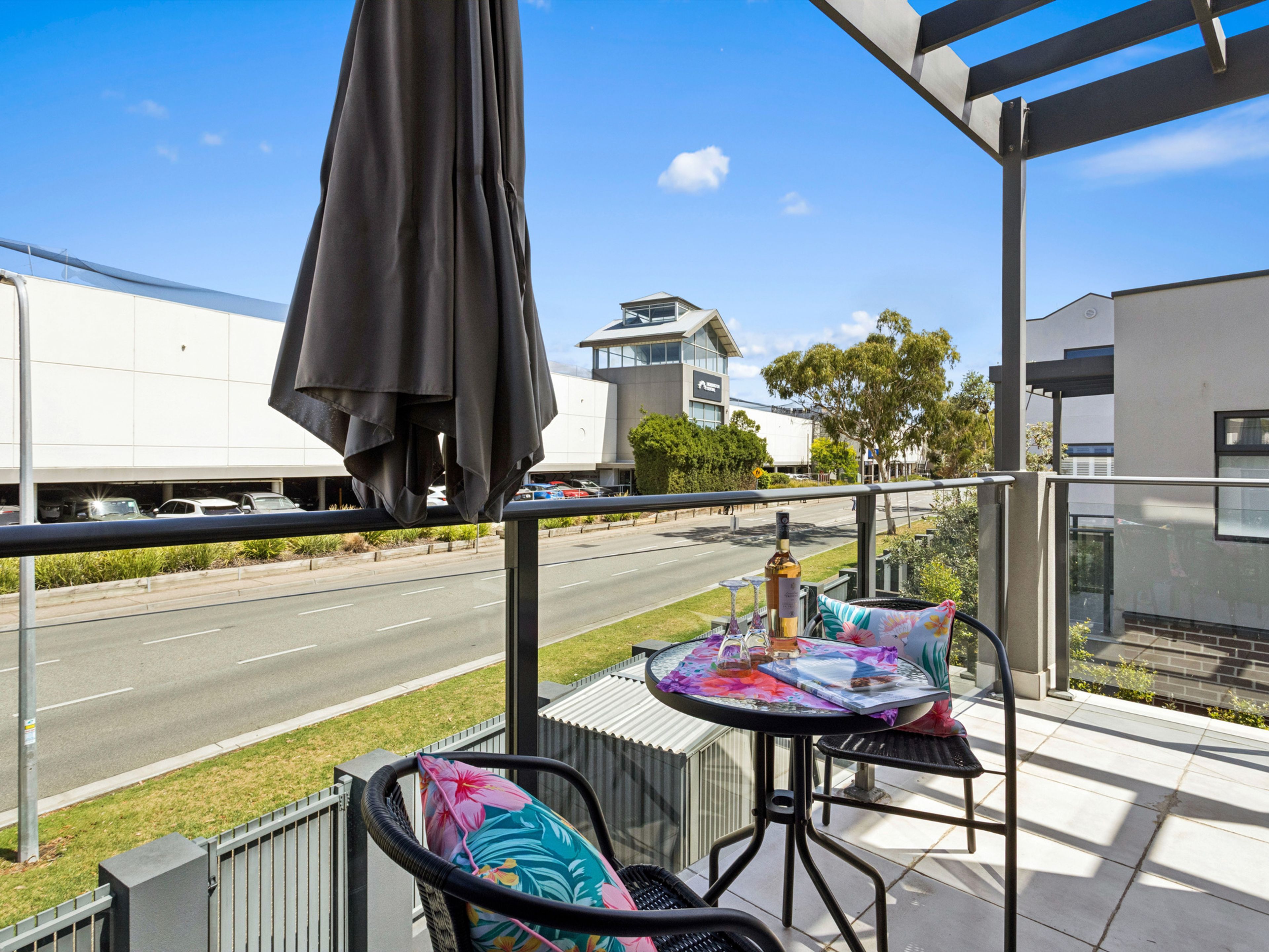 A balcony with a table, chairs, and an umbrella.