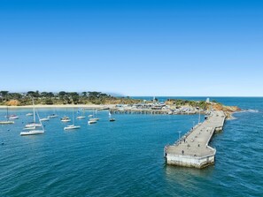 A coastal marina with boats, a pier, and a beach in the background. - Azura on Gordon Mornington Townhouse Near Beach (Mornington)