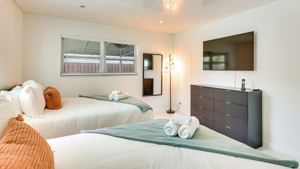 A hotel room with two beds, a wardrobe, a mirror, and a window. - 3 Mi to Sea! Family Pool House in Fort Lauderdale (Fort Lauderdale)